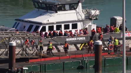A group of people are brought into the Border Force compound in Dover, Kent after a small boat incident in the Channel on 9 September.