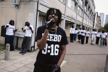 Reperi i muzikës underground Ceebo pozon në rrugë me një grup njerëzish që veshin bluza Ceebo.