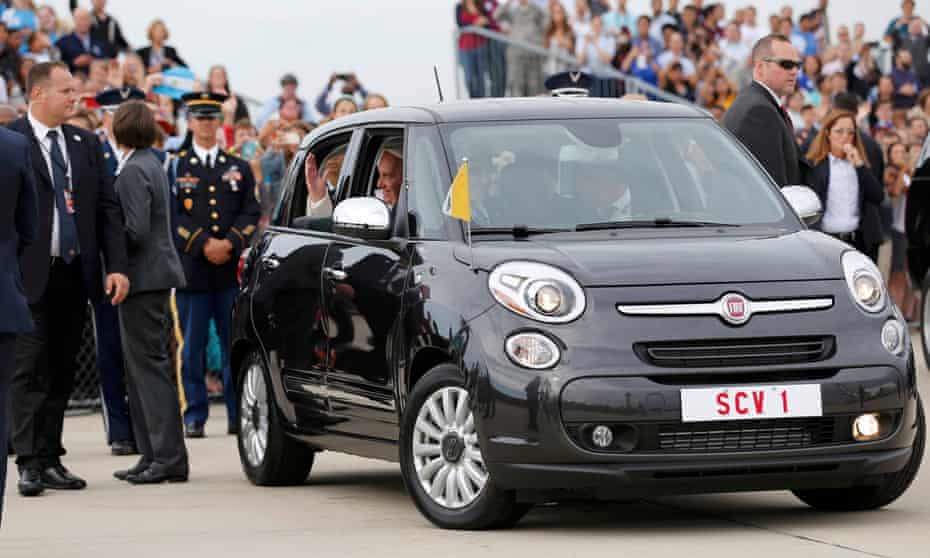 Pope Francis waves as he is driven away in a Fiat 500 model after arriving in the United States at Joint Base Andrews outside Washington on Tuesday.