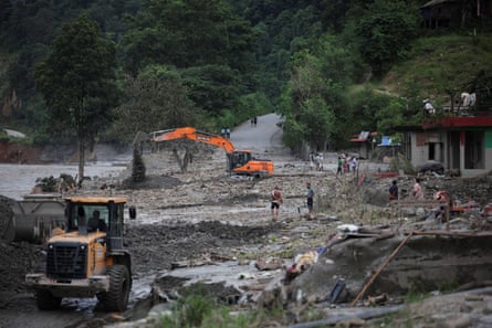 An excavator repairs a damaged road in Nepal near the Trishuli River on Monday
