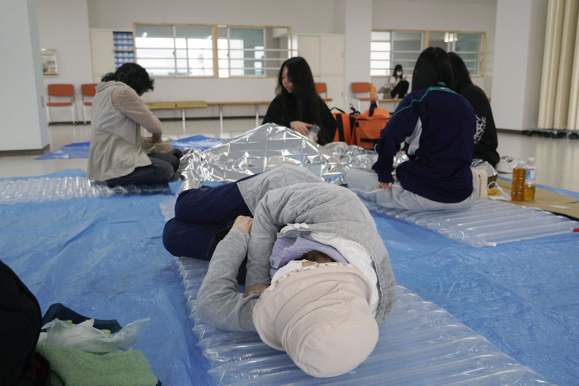 A woman lies down at an evacuation tower in Kushiro, Hokkaido, northern Japan. Photograph: KYODO/Reuters