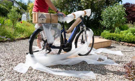 Someone unpacks a new e-bike in their garden