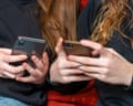 Two teenage girls on their phones