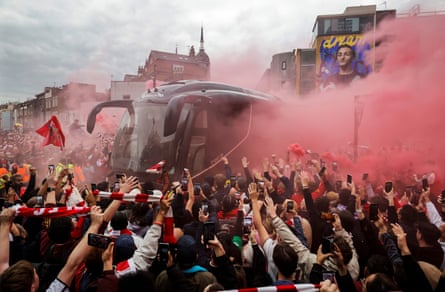 Arsenal fans greet the team bus with flares