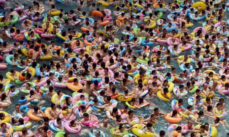 Thousands of people at a saltwater pool in Suining, China, where 800 million people have risen out of poverty.
