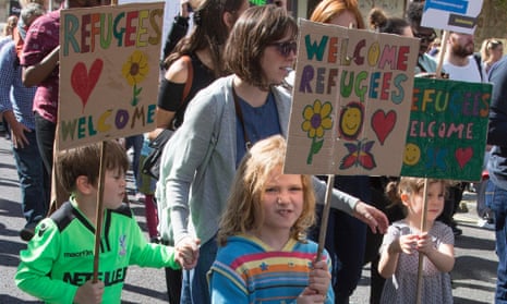 children with 'welcome refugee' signs
