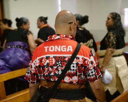 A man wears a patterned Tonga rugby league shirt at a congregation