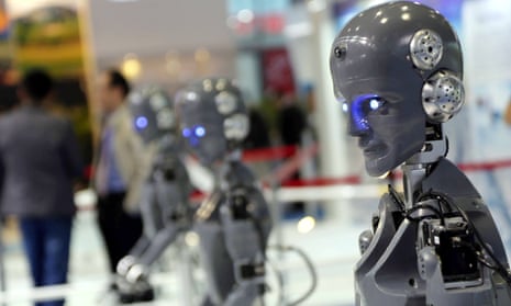A line of human-shaped robots on display at an industry fair.