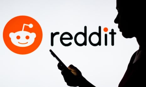 A photo of a woman holding a smartphone in front of the Reddit logo.