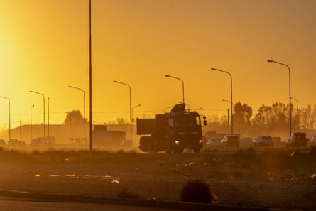 A heavy vehicle driving along a dusty road