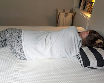 The reviewer, lying on their side, on the Emma Hybrid Premium Mattress.