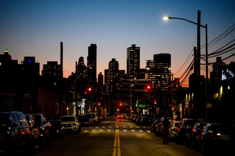 A Queens street with Manhattan’s skyline in the background during sunset.