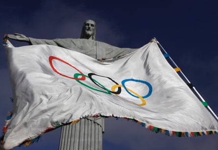The Olympic Flag flies in front of Christ the Redeemer statue in Rio de Janeiro