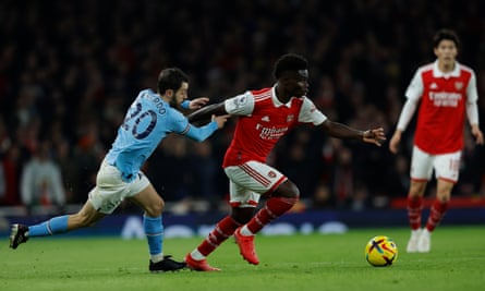 Bukayo Saka del Arsenal corre el balón bajo la presión de Bernardo Silva del Manchester City.
