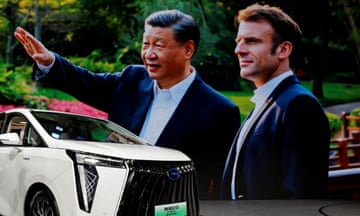 An image of Xi Jinping with Emmanuel Macron displayed at the Auto China show – it is projected on a giant screen, with a silver GAC Trumpchi E9 MPV vehicle seen in the foreground