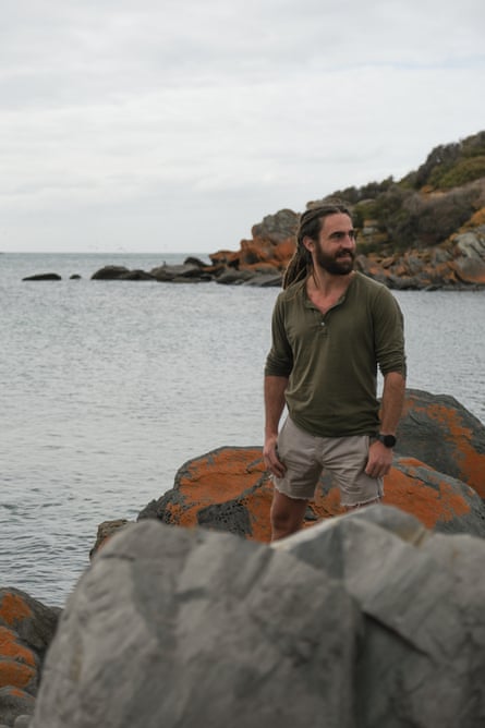 Man standing between rocks next to beach