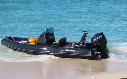 Black RHIB beached in shallow water