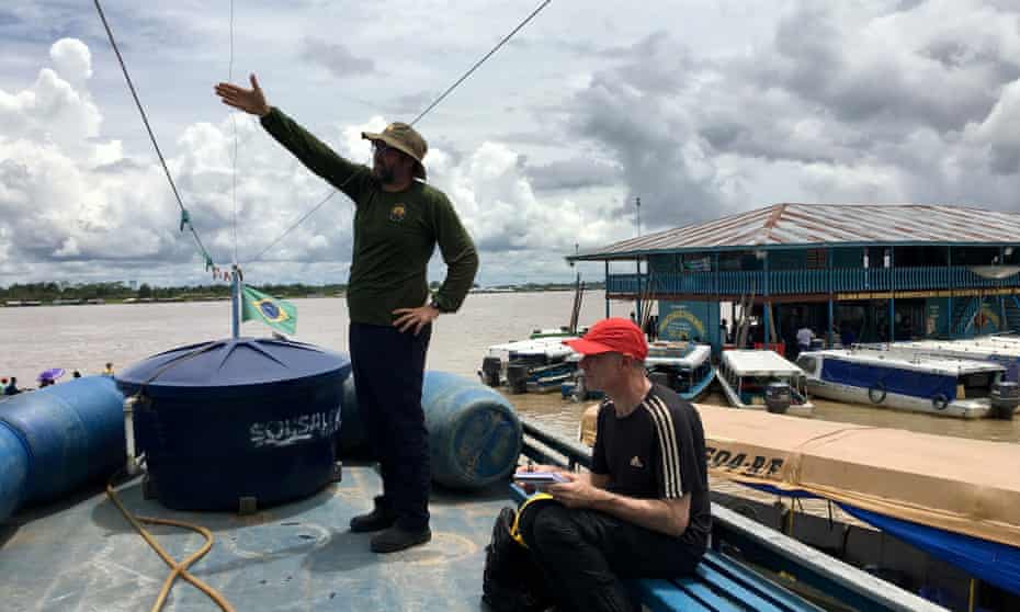 Dom Phillips, sitting, and Bruno Pereira on the Amazon in 2018.