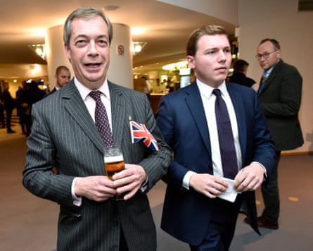 Two men in suits, one slightly in foreground holding a Union Jack and a glass of beer.