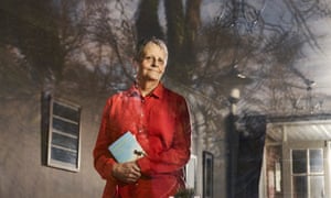 Wendy Mitchell standing in front of her house, with her book in her hands