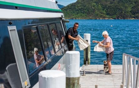 A crewman hands a woman her mailbag