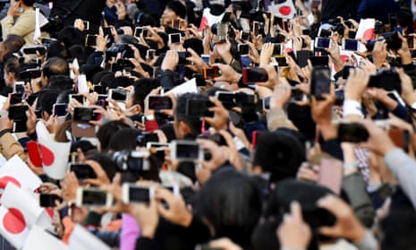 Spectators use smartphones, trying to capture images of the royal motorcade in Tokyo