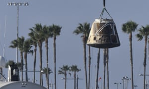 A spaceship capsule being lifted by a crane