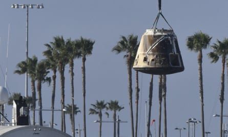 A spaceship capsule being lifted by a crane