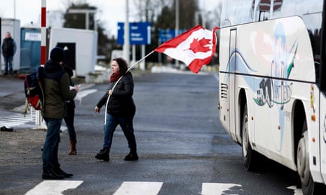 A demonstrator waves a Canadian flag in a parking lot outside Brussels on 14 February.