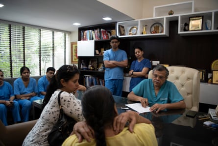 Dr GP Dureja, surrounded by medical trainees, talks to a patient at the Delhi Pain Management Centre.