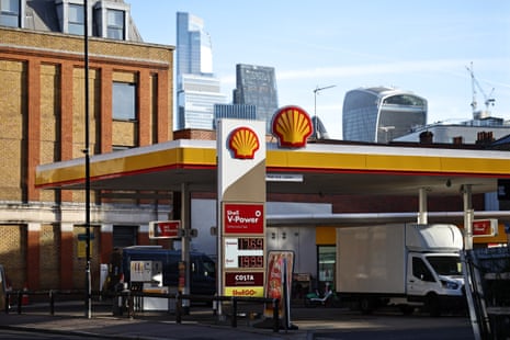 A long shot of an urban Shell petrol station with tall buildings in the background