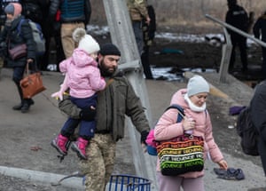 A serviceman helping carry a child during the evacuation of residents from Irpin, Ukraine.