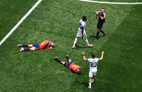 Referee Michael Oliver calls for medical attention after Spain's Dani Olmo and Mikel Oyarzabal clash heads.