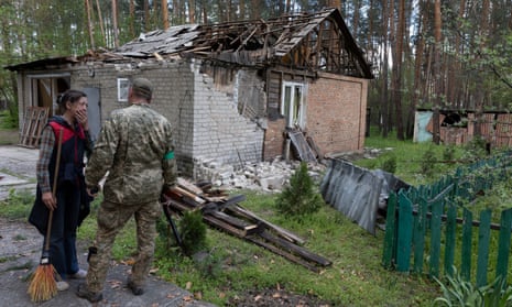 A woman whose house was struck by shelling talks to a Ukrainian commander near the frontline in Sviatohirsk, Donetsk