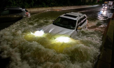 A motorist drives a car through a flooded expressway in Brooklyn, New York, early on Thursday, as flash flooding and record-breaking rainfall brought by the remnants of Storm Ida swept through the area.