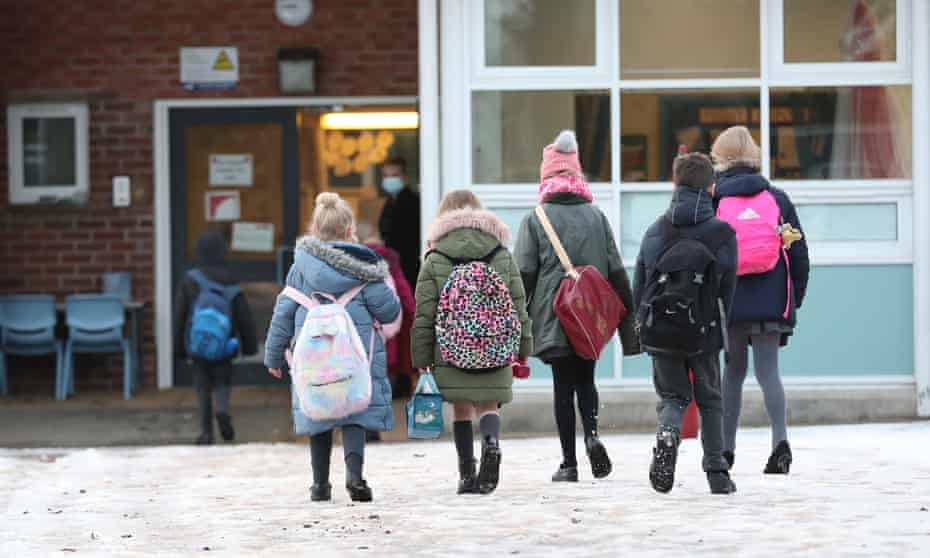Primary school children enter a school