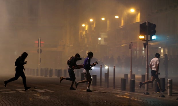 People in Marseille’s old port area run away after police use tear gas to disperse rival groups following England’s match against Russia.