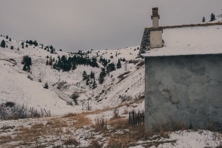 A house stands in front of a cleft between two hills.