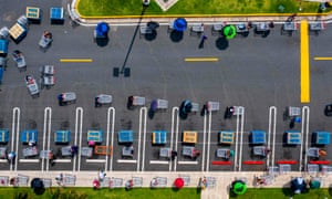 People keep their distance while queuing at a retail store during mandatory confinement to counter the new coronavirus in Carolina, Puerto Rico, on April 7, 2020.