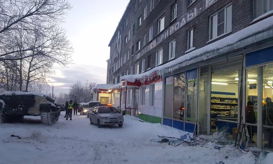 Police examine a smashed shop window in Apatity, Russia Wednesday.
