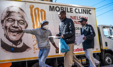 A volunteer directs two men towards a medical tent where they will be tested for Covid-19 as well as HIV and TB, in downtown Johannesburg.