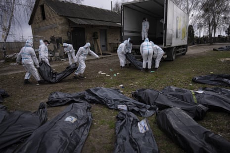 Volunteers load bodies of civilians killed in Bucha onto a truck to be taken to a morgue for investigation, on the outskirts of Kyiv, Ukraine, on Tuesday.