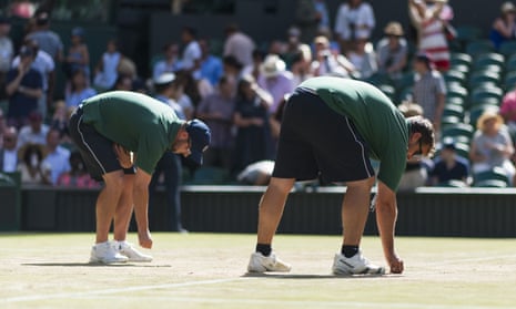 Wimbledon grounds staff repair court surfaces between matches on day six.