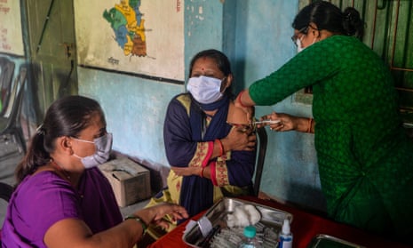 A health worker inoculates a woman with a dose of the Covishield vaccine at a vaccination camp in Milan More village, Siliguri, India.