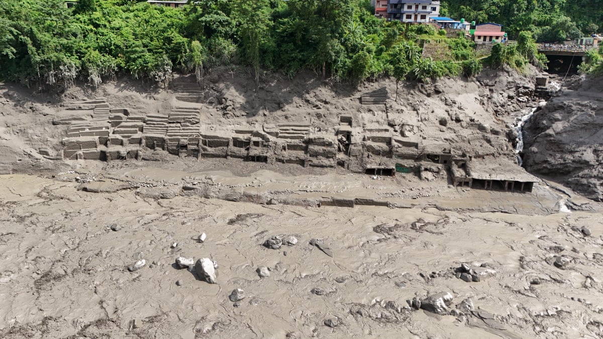 An aerial view shows buildings and infrastructure damaged along the swollen Trishuli River