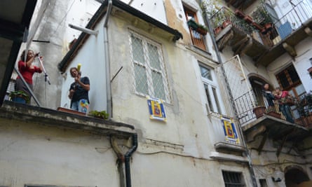 Maksim Cristan and Daria Spada perform from a balcony in the centre of Turin