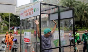 A woman is sprayed in a makeshift disinfection chamber in Jakarta where tehere have been hundreds of cases of Covid-19.