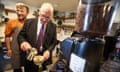 John Swinney pouring milk into a coffee cup with a man stood behind him