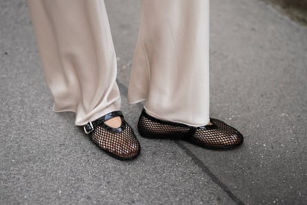 Aylin Sengül wears cream satin wide-leg trousers with black mesh flats - legs seen only