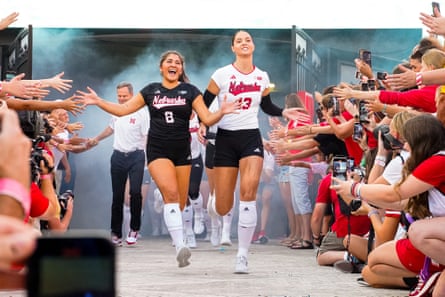 Nebraska Cornhuskers outside hitter Merritt Beason (13) and libero Lexi Rodriguez (8) run out of the tunnel before Wednesday’s match against the Omaha Mavericks at Memorial Stadium.